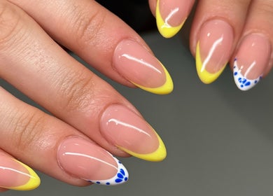 Vibrant yellow nails with blue accents at Lilac Nails | Ongles de Lilas in Montréal, Québec, CA.