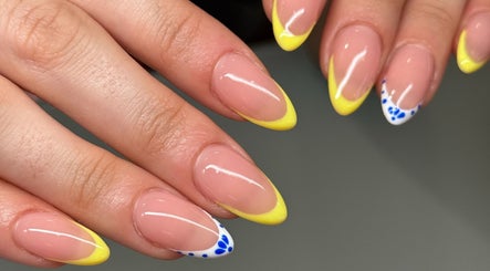 Vibrant yellow nails with blue accents at Lilac Nails | Ongles de Lilas in Montréal, Québec, CA.