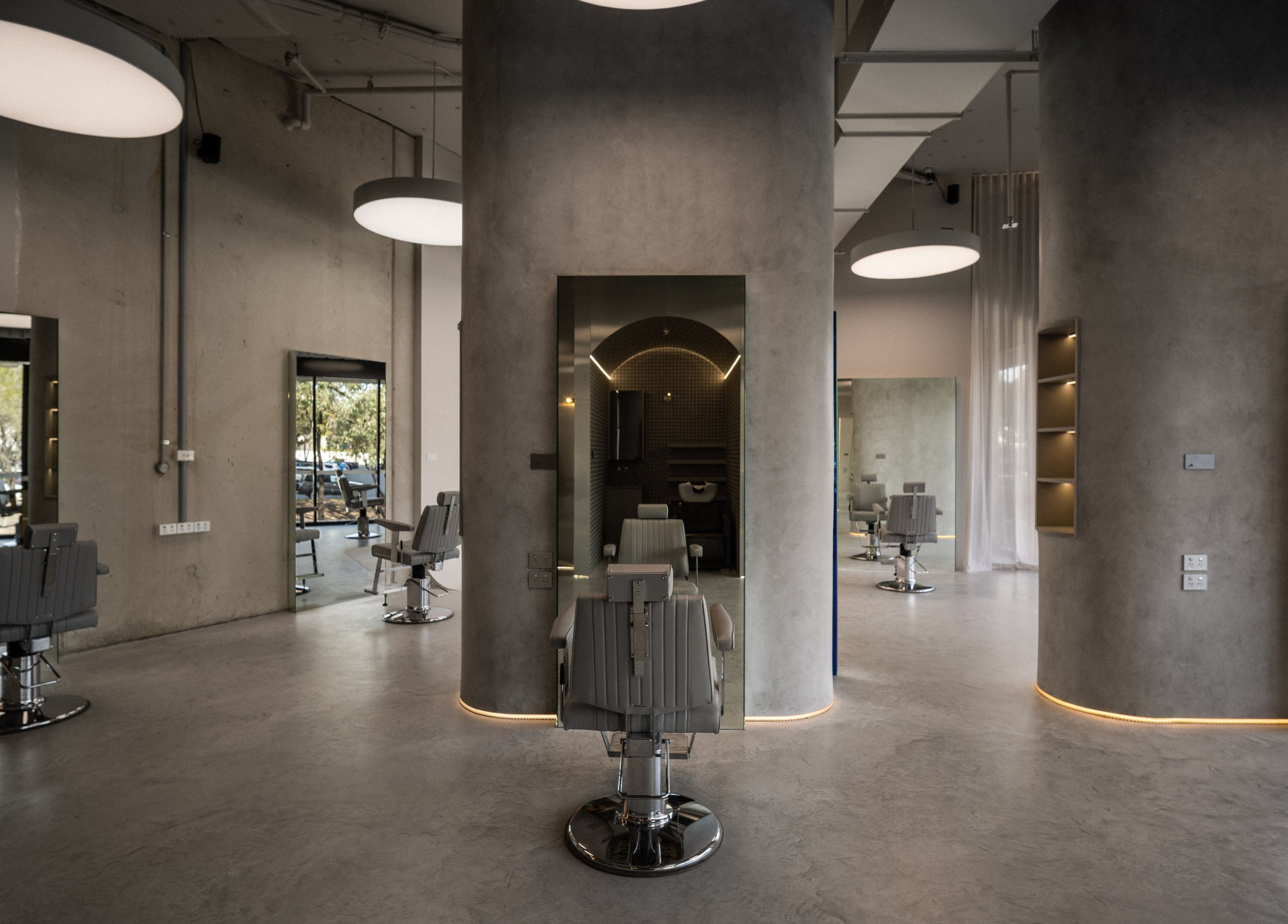 Spacious and modern interior of Alkami salon in Belconnen, Australian Capital Territory, AU, with sleek barber chairs.