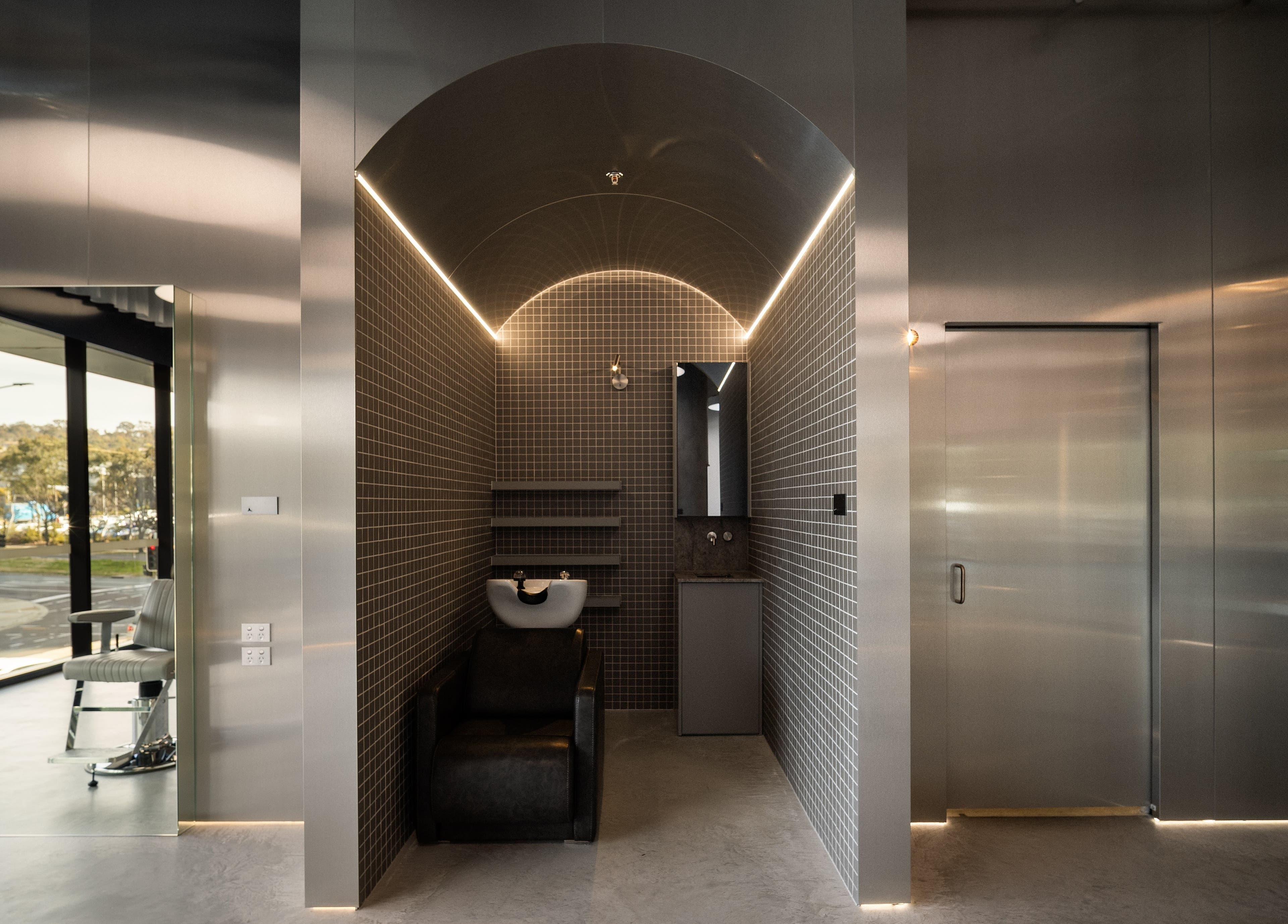 Modern salon interior at Alkami, Belconnen, Australian Capital Territory, AU featuring sleek gray tiles and stylish seating.