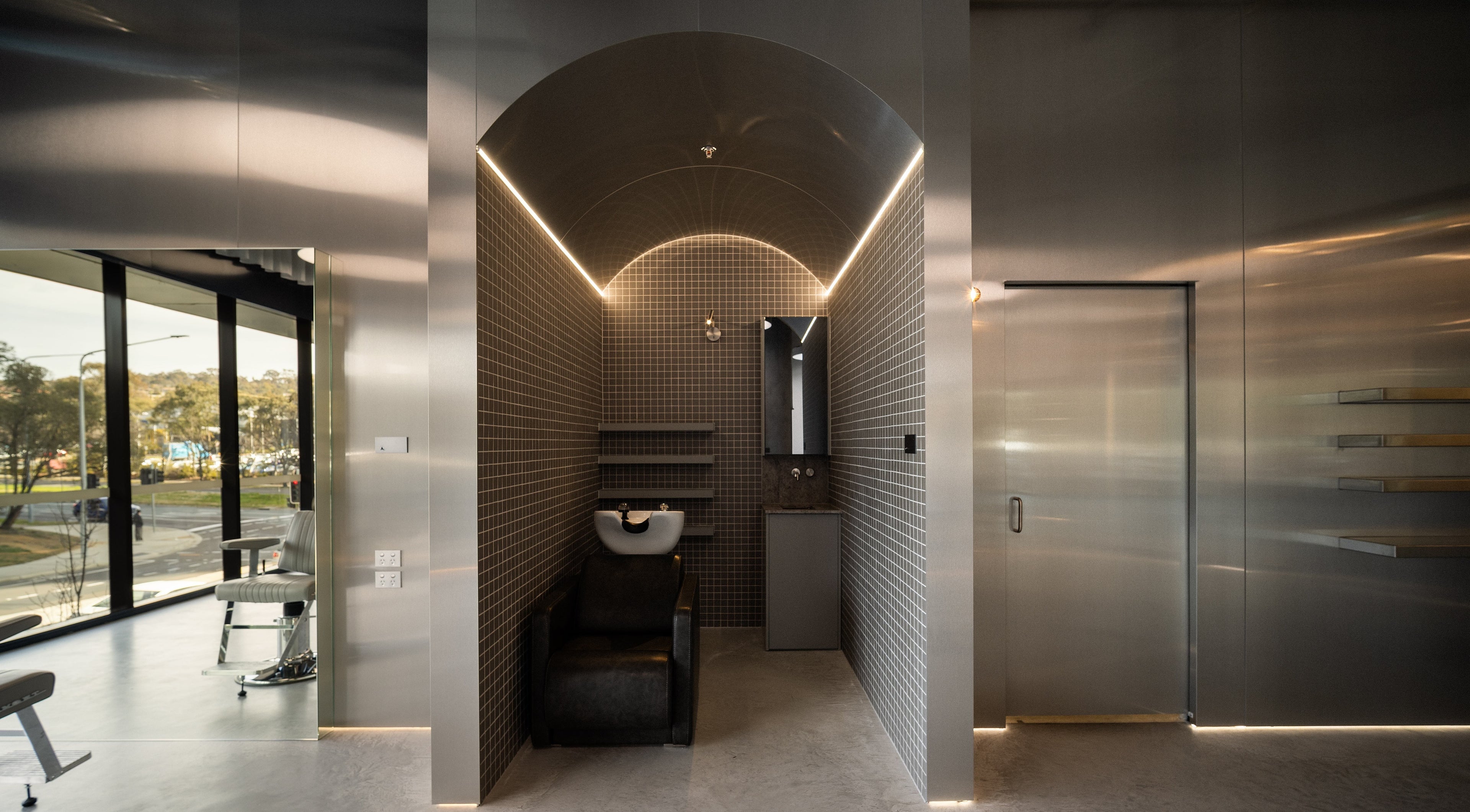 Modern salon interior at Alkami, Belconnen, Australian Capital Territory, AU featuring sleek gray tiles and stylish seating.