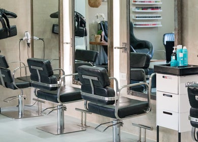 Interior moderno de Salon Bruno en Las Terrenas, Samaná, DO con asientos estilo salón y productos de belleza.