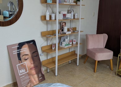 Espacio acogedor en Glow to Go, Mérida, Yucatán, MX. Sillas y estantería con productos de belleza.