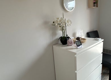 Coin détente chez Studio LS, Bize-minervois, Occitanie, FR. Décoration épurée avec fleurs blanches et horloge.