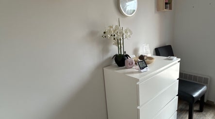 Coin détente chez Studio LS, Bize-minervois, Occitanie, FR. Décoration épurée avec fleurs blanches et horloge.