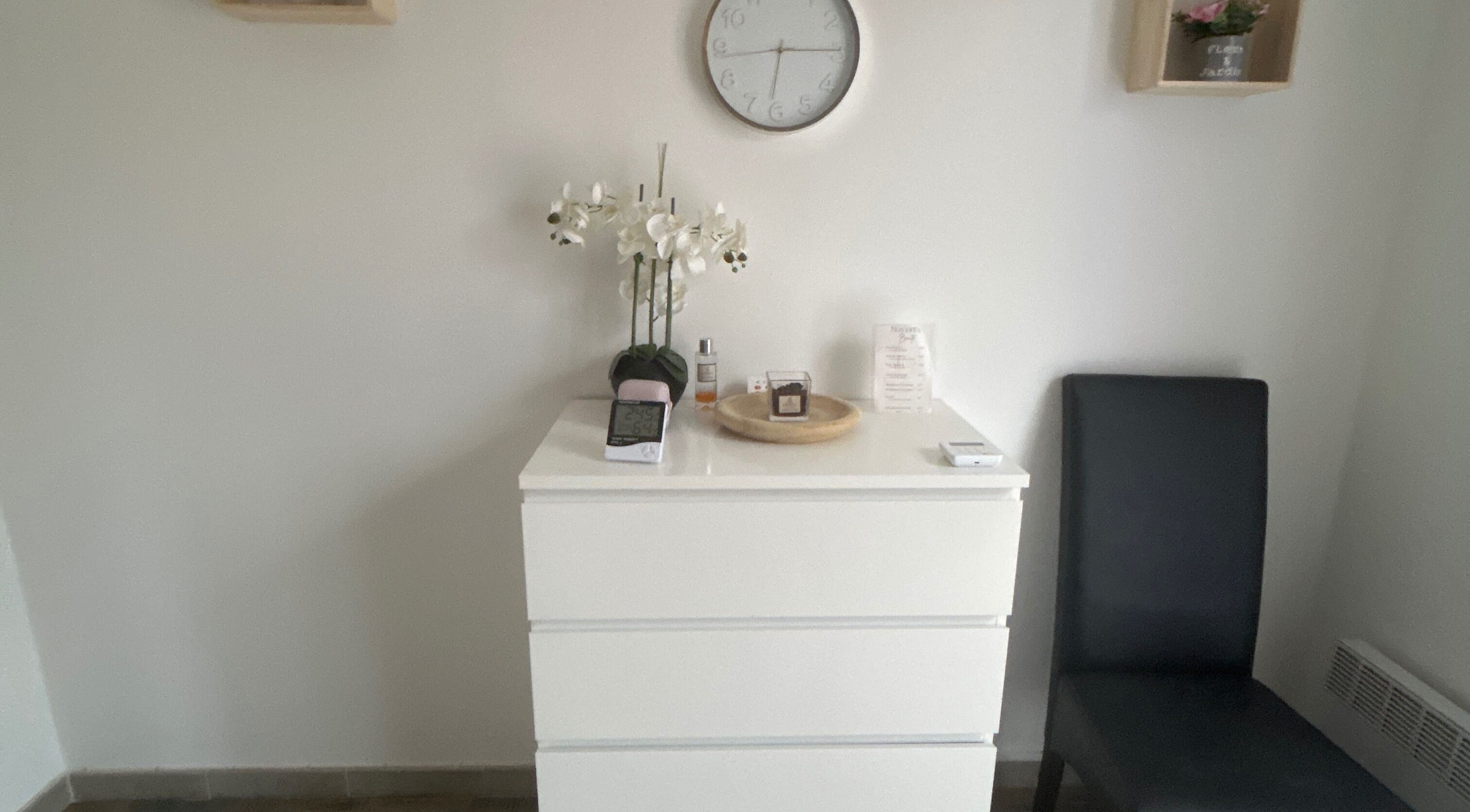 Espace accueil élégant à Studio LS, Bize-minervois, Occitanie, FR, avec meuble blanc et décoration florale.