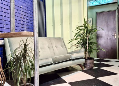 Stylish seating area at Kelly Hair Studio in London, England, GB featuring a modern sofa and vibrant decor.