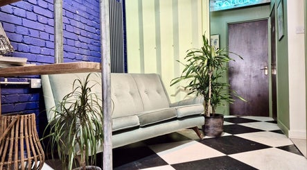 Stylish seating area at Kelly Hair Studio in London, England, GB featuring a modern sofa and vibrant decor.
