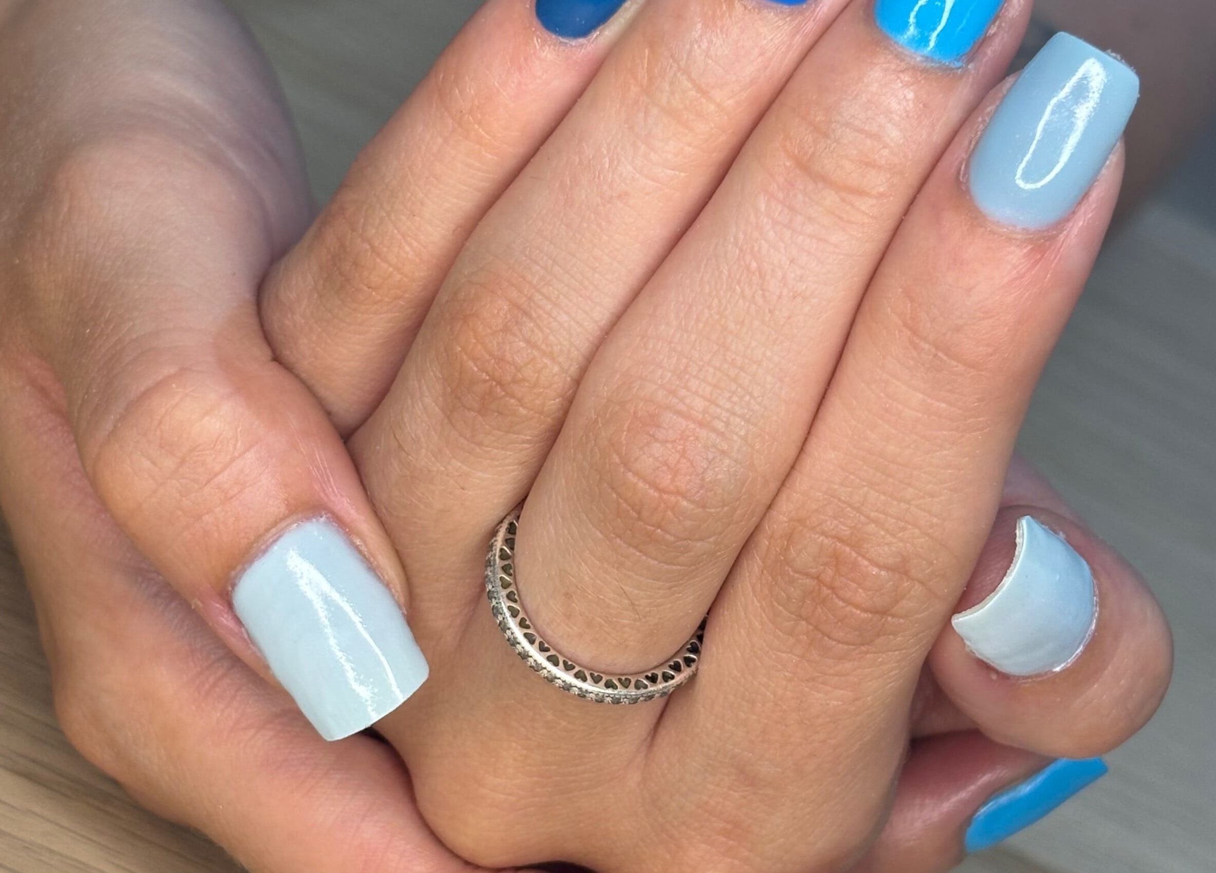 Close-up of blue and white nail art by By Ells, Redditch, England, GB, showcasing manicure detail.
