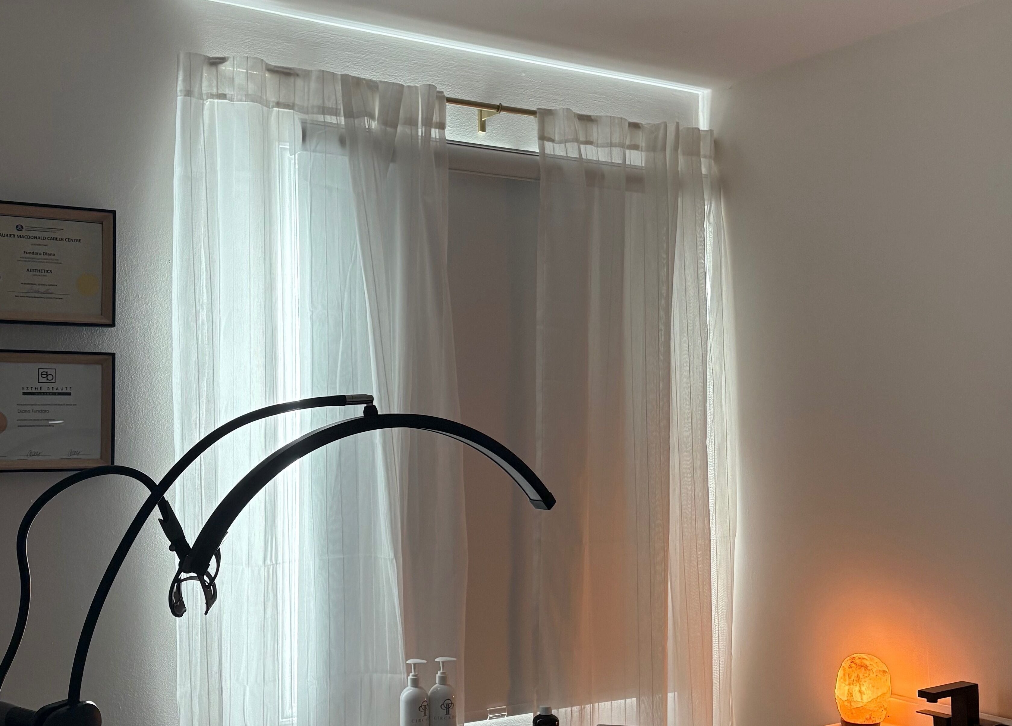 Calm treatment room at VitaGlow Esthétiques, Laval, Québec, CA with warm lighting and certificates displayed.