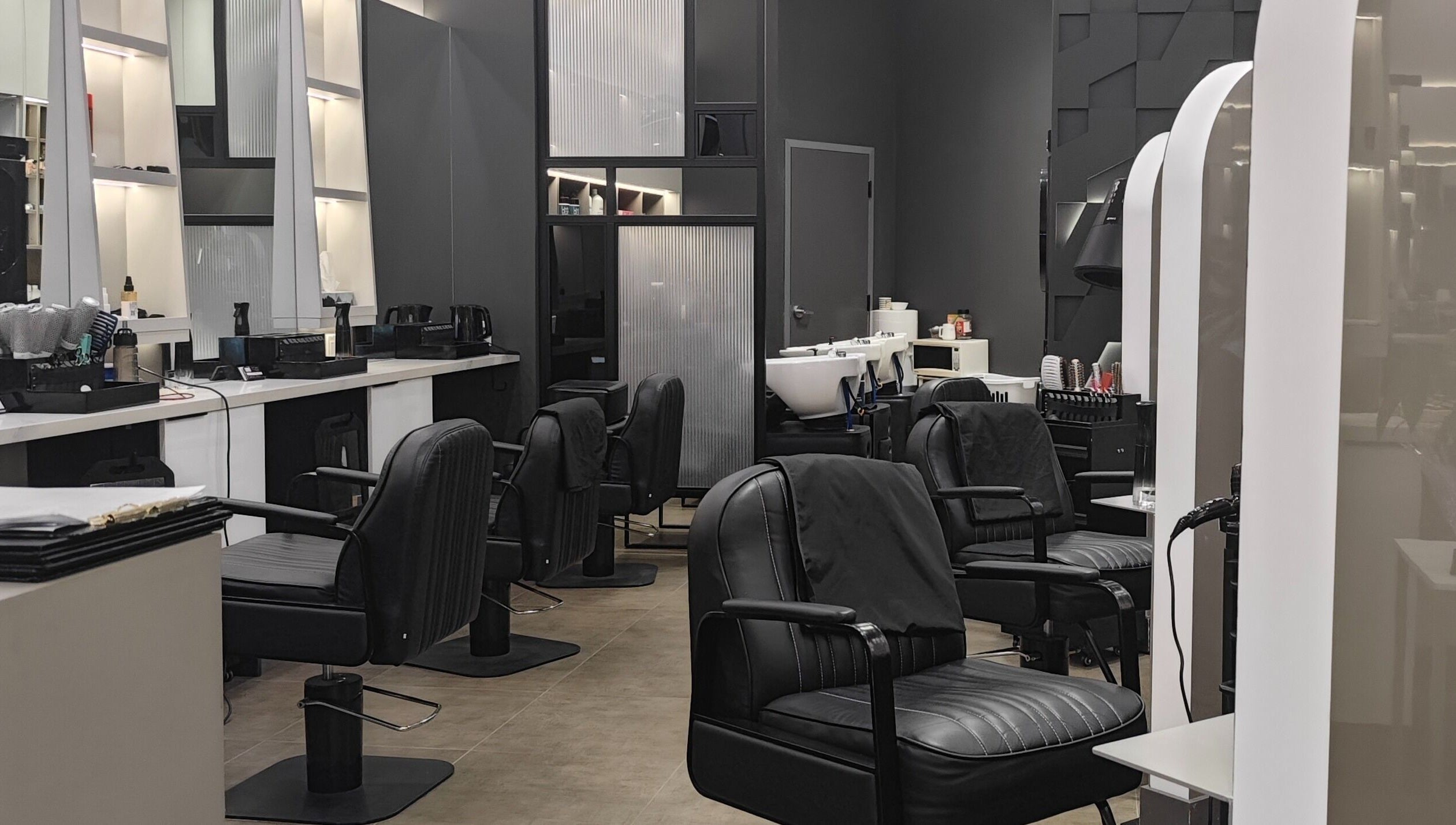 Stylish interior at Gatsby Studio Salon & Nails, Richmond Hill, Ontario, CA, featuring plush chairs and sleek decor.
