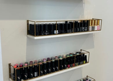 Nail polish shelves at 11:11 Nails By Jordan in Dalton Gardens, Idaho, US showcasing diverse colors.