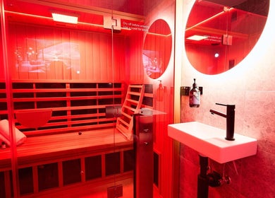 Relaxing sauna room at Vita Health Club, North Willoughby, New South Wales, AU with red ambient lighting.