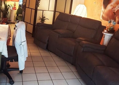 Comfortabele loungehoek bij Massagesalon Nostalgia, Alken, BE, met luxe stoelen en sfeervolle verlichting.