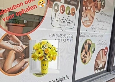 Buitenzijde van Massagesalon Nostalgia in Alken, BE met rustgevende massagebeelden en bloemen.