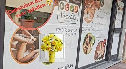 Buitenzijde van Massagesalon Nostalgia in Alken, BE met rustgevende massagebeelden en bloemen.