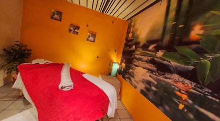 Interieur van Massagesalon Nostalgia in Alken, BE met een sfeervolle massagetafel en warme kleuren.