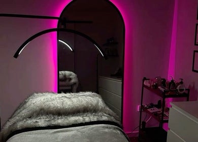 Luxurious treatment room at LASHOGRAPHER, Leicester, England, GB, featuring pink neon lights and cozy decor.