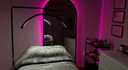 Luxurious treatment room at LASHOGRAPHER, Leicester, England, GB, featuring pink neon lights and cozy decor.