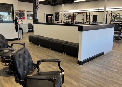 Modern salon interior at Ruben Carreon in Yuba City, California, US featuring stylish black chairs and mirrors.