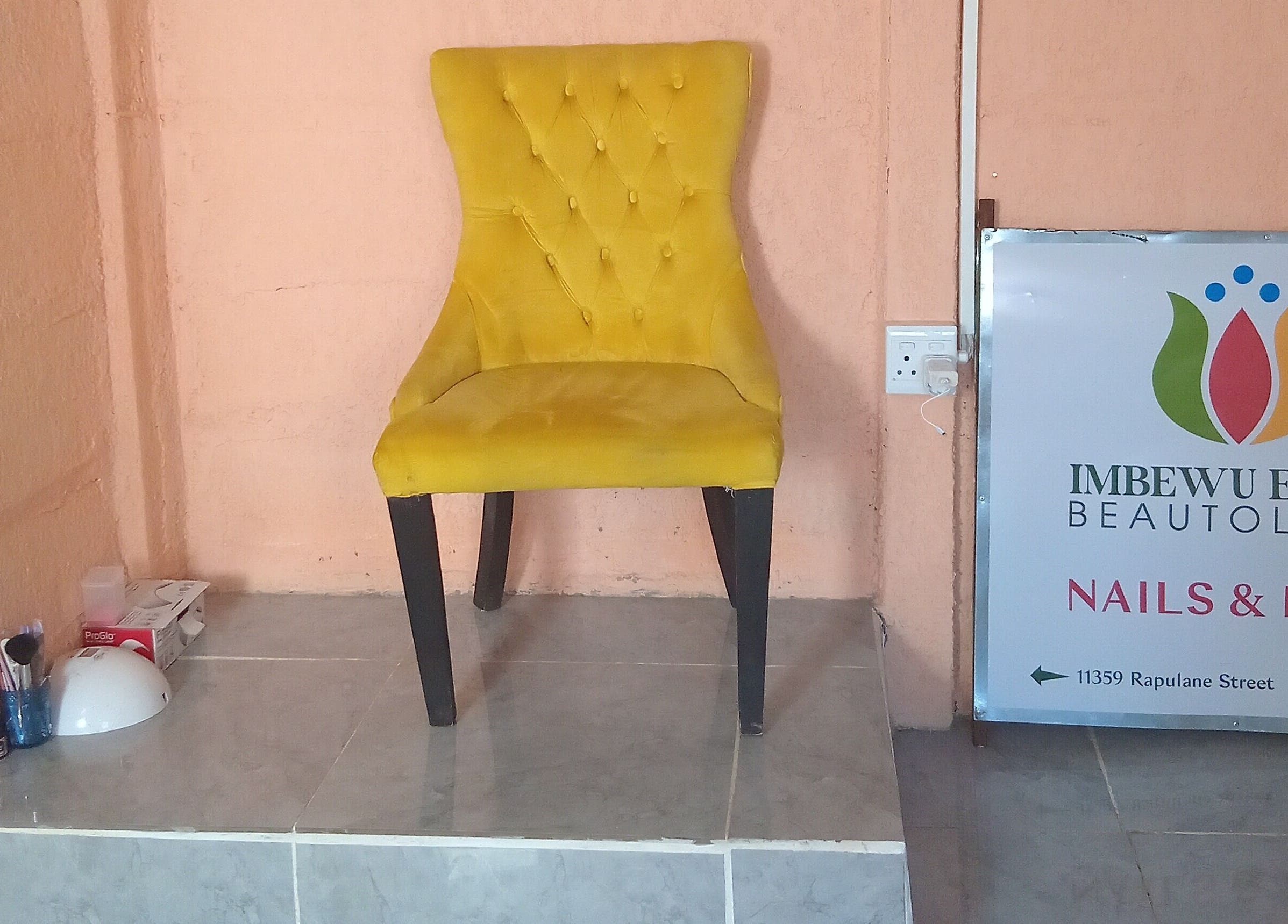 Yellow chair at Imbewuenhle Beautology, Benoni, Gauteng, ZA, showcasing a chic ambience.