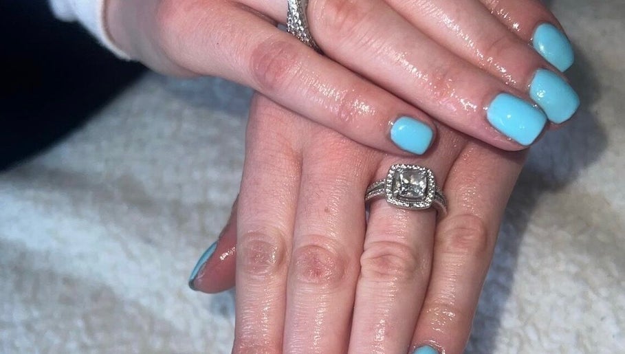 Gleaming blue nails with rings at RDHNails, Birmingham, England, GB showcasing modern manicure artistry.
