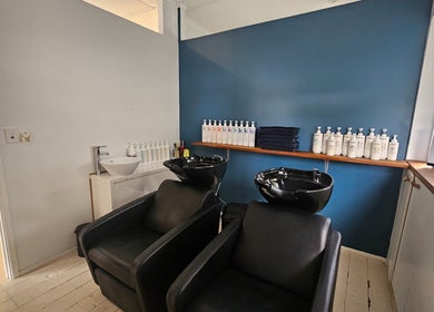 Relaxing shampoo area at Indie Hair in Windsor, Queensland, AU featuring black wash stations and haircare products.