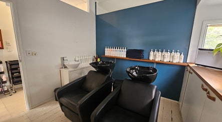 Relaxing shampoo area at Indie Hair in Windsor, Queensland, AU featuring black wash stations and haircare products.