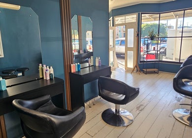 Chic salon interior at Indie Hair, Windsor, Queensland, AU, featuring modern chairs and large windows.