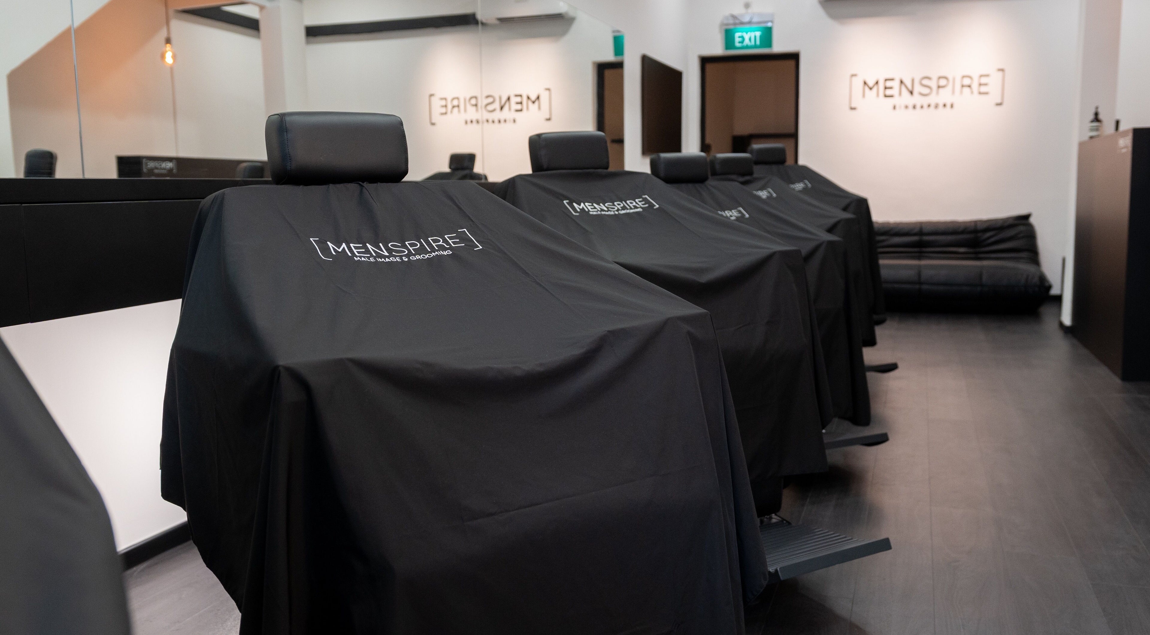 Interior of MENSPIRE Singapore, featuring sleek barber chairs in Singapore, SG.