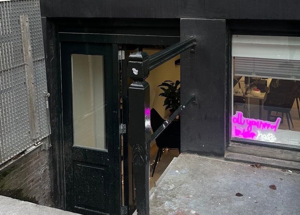 Entrance to Juss.nail, Amsterdam, Noord-Holland, NL, with sleek black door and neon signage.