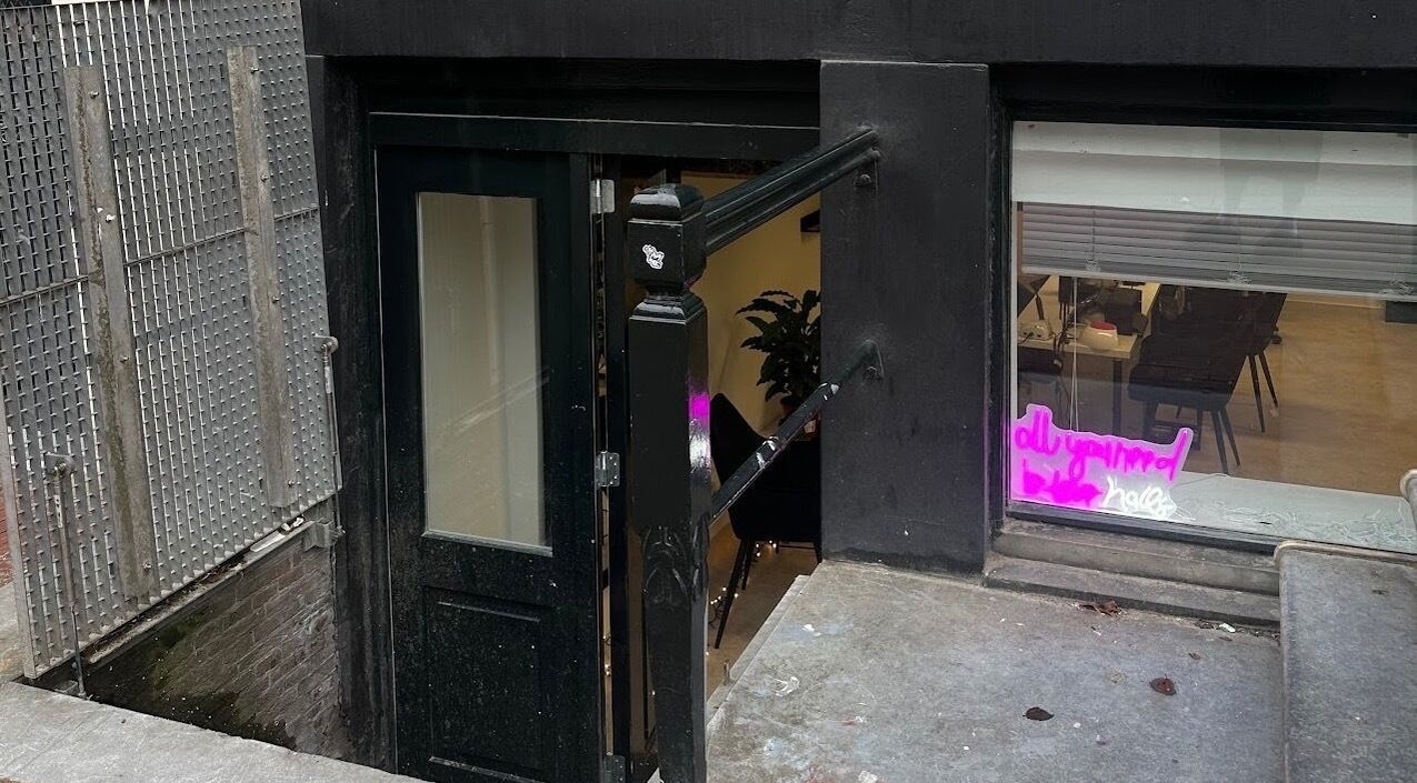 Entrance to Juss.nail, Amsterdam, Noord-Holland, NL, with sleek black door and neon signage.