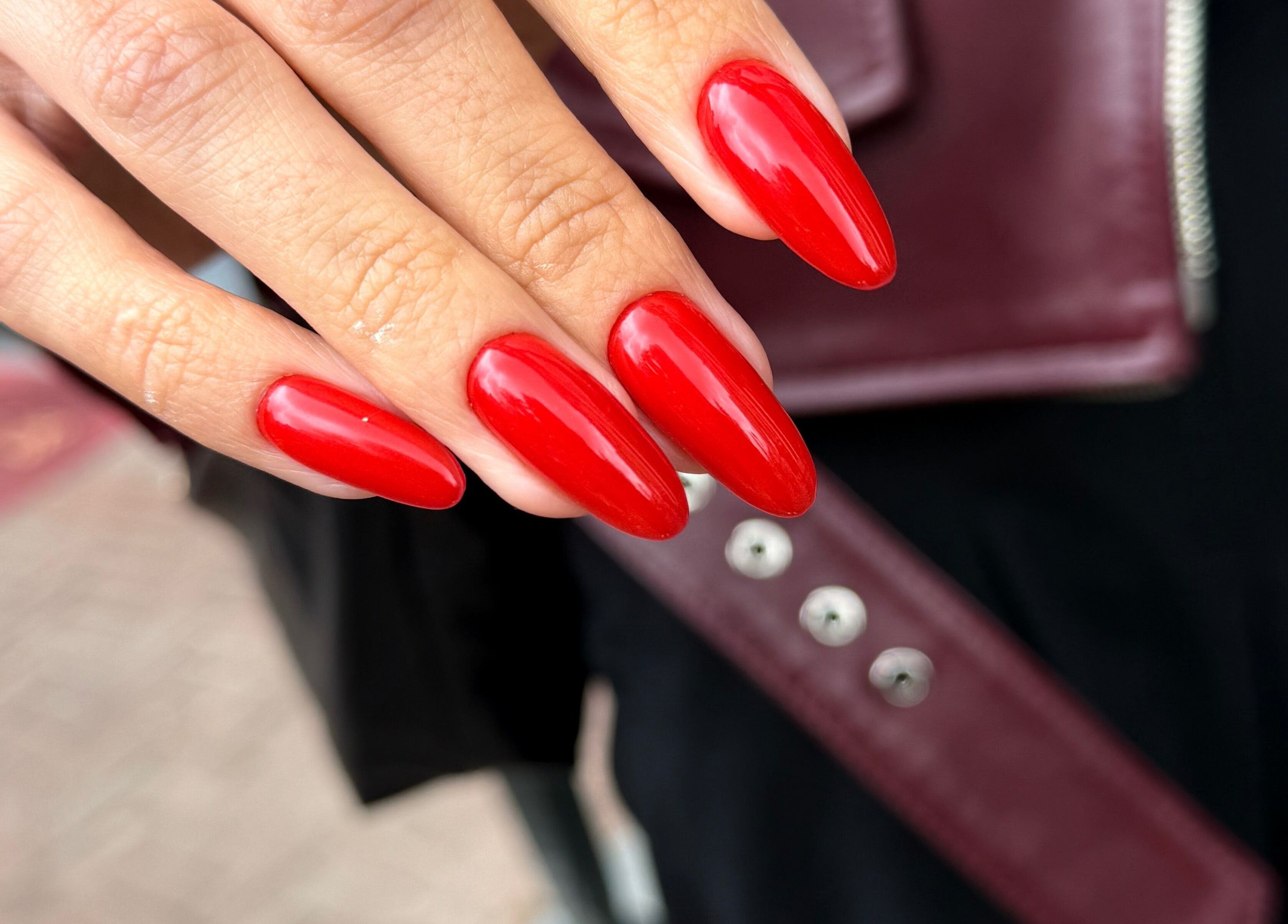 Close-up of vibrant red nails at Juss.nail, Amsterdam, Noord-Holland, NL, showcasing glossy finish and precision.