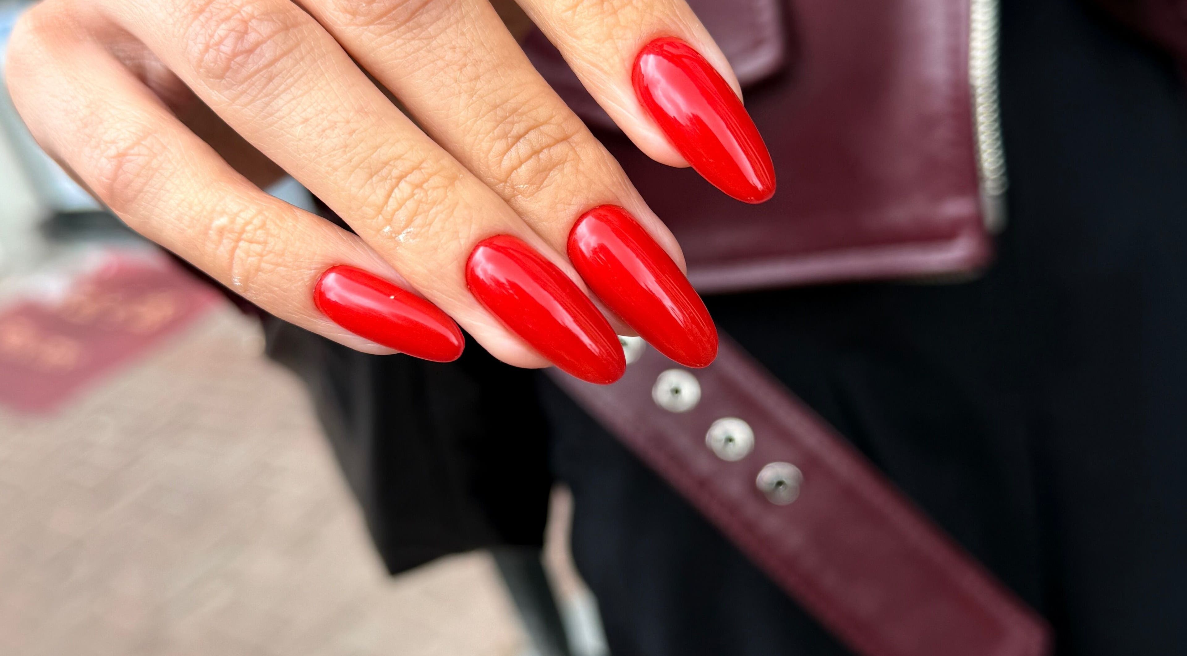 Close-up of vibrant red nails at Juss.nail, Amsterdam, Noord-Holland, NL, showcasing glossy finish and precision.