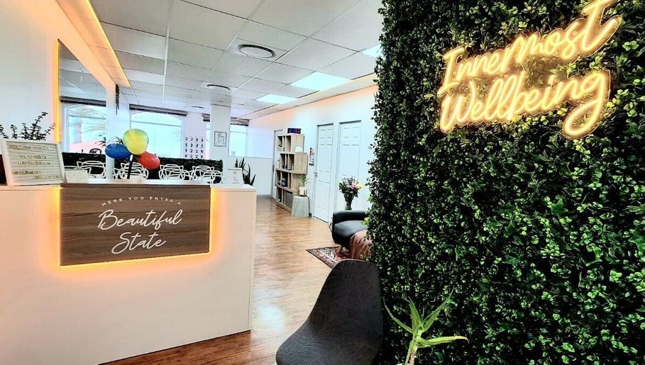 Reception area at Innermost Wellbeing in Cape Town, Western Cape, ZA, featuring lush greenery and seating.