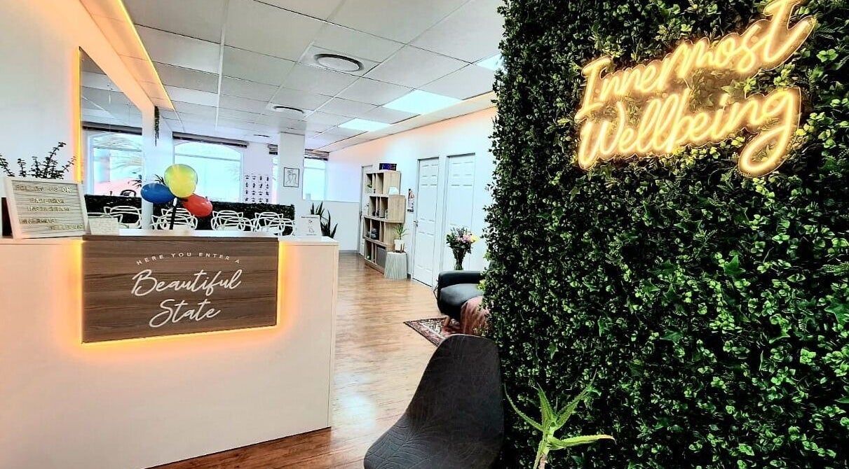 Reception area at Innermost Wellbeing in Cape Town, Western Cape, ZA, featuring lush greenery and seating.