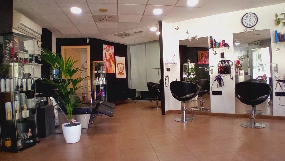 Interior moderno de Perruqueria Sant Jordi en Vilanova I La Geltrú, Cataluña, ES, con sillones y decoración estilizada.