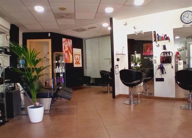 Interior moderno de Perruqueria Sant Jordi en Vilanova I La Geltrú, Cataluña, ES, con sillones y decoración estilizada.