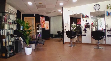 Interior moderno de Perruqueria Sant Jordi en Vilanova I La Geltrú, Cataluña, ES, con sillones y decoración estilizada.