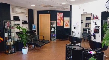 Interior moderno de Perruqueria Sant Jordi en Vilanova I La Geltrú, Cataluña, ES con sillas elegantes y decoración artística.