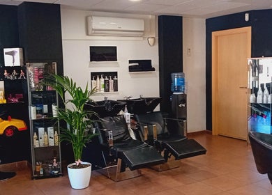 Zona de lavado en Perruqueria Sant Jordi en Vilanova I La Geltrú, Cataluña, ES, con sillas y decoración moderna.
