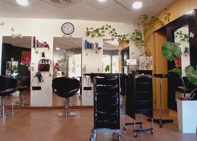 Interior moderno de Perruqueria Sant Jordi en Vilanova I La Geltrú, Cataluña, ES, con sillas de diseño.