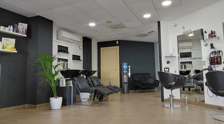 Interior moderno de Perruqueria Sant Jordi, Vilanova I La Geltrú, Cataluña, ES con sillas negras y espejos.