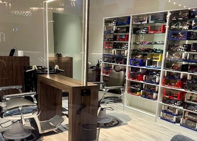Aura salon & spa interior at Al janabiyah, showcasing modern barber chairs and a sleek display.