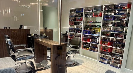 Aura salon & spa interior at Al janabiyah, showcasing modern barber chairs and a sleek display.