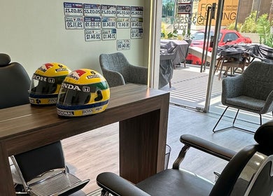 Aura salon & spa in Al janabiyah, BH features stylish decor with F1 helmets and modern chairs.