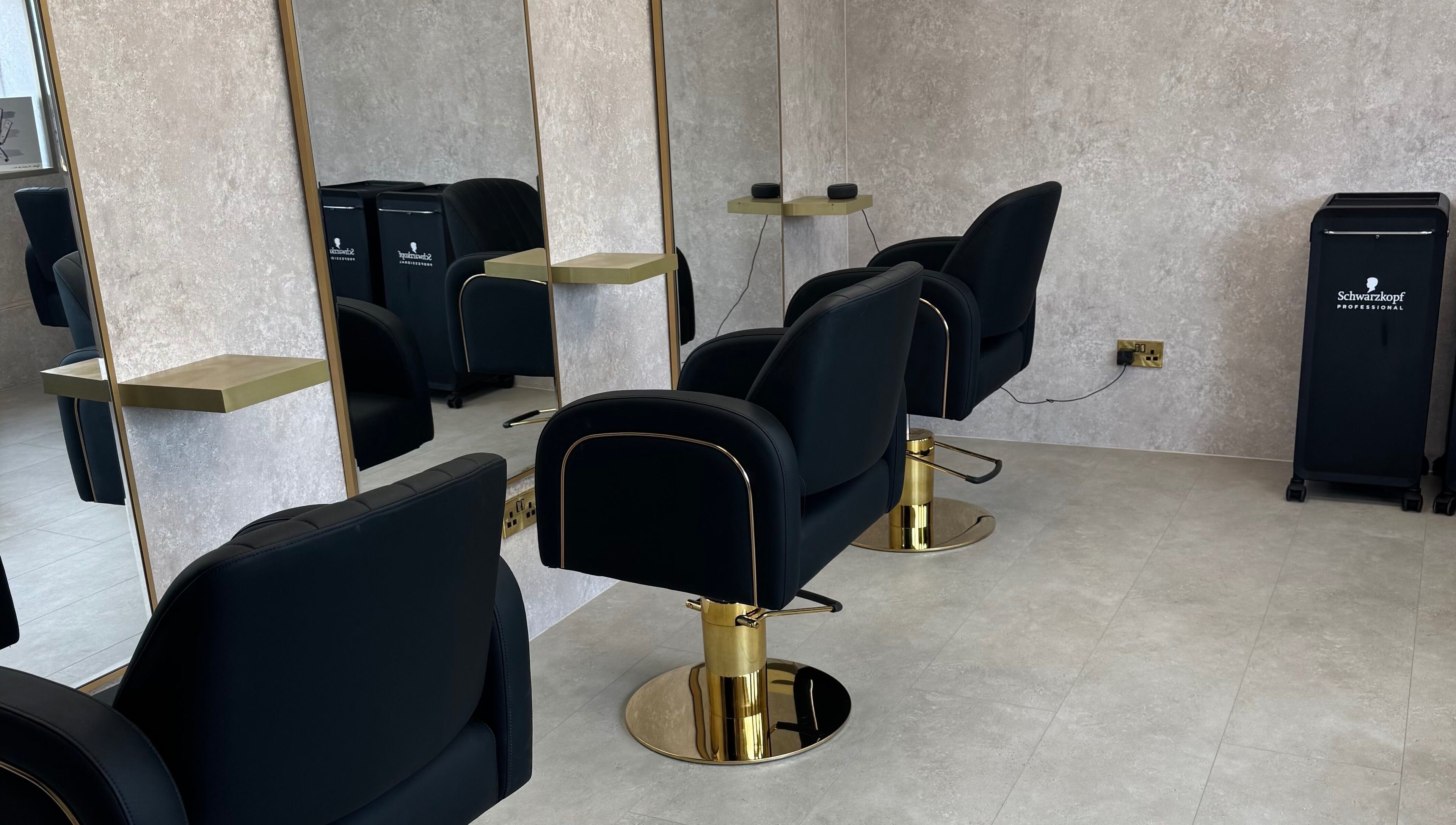 Sleek salon setup at The Hair Edit by caitlin- at Solea Salon in Motherwell, Scotland, GB with modern black chairs.