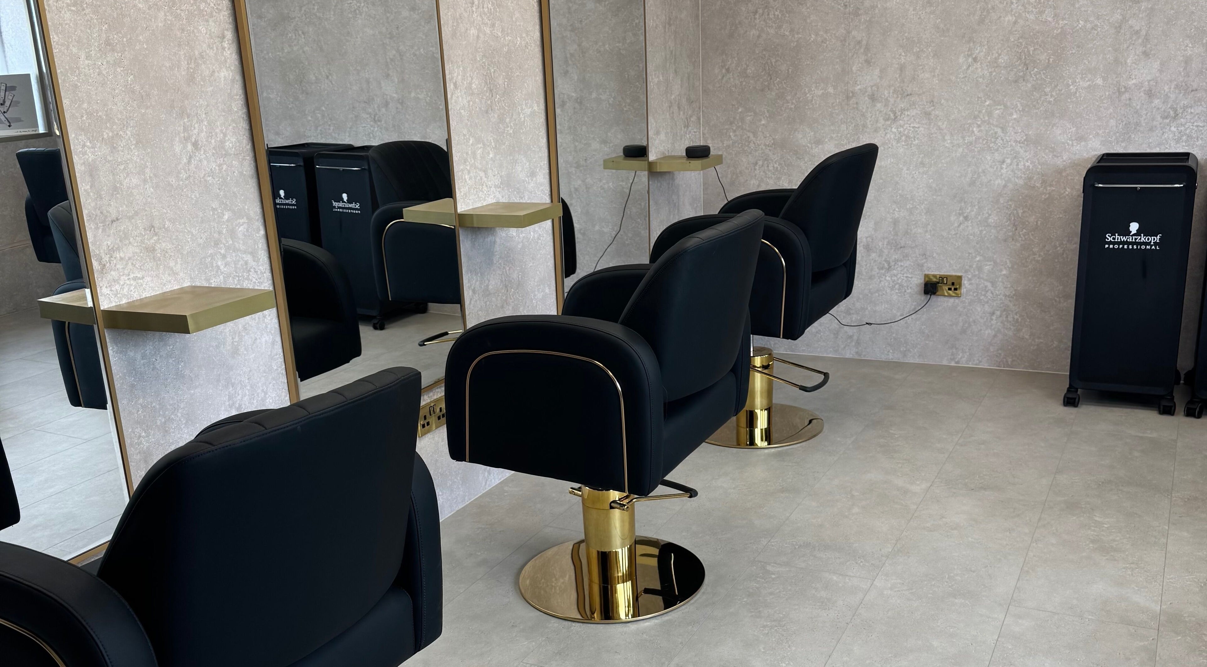Sleek salon setup at The Hair Edit by caitlin- at Solea Salon in Motherwell, Scotland, GB with modern black chairs.