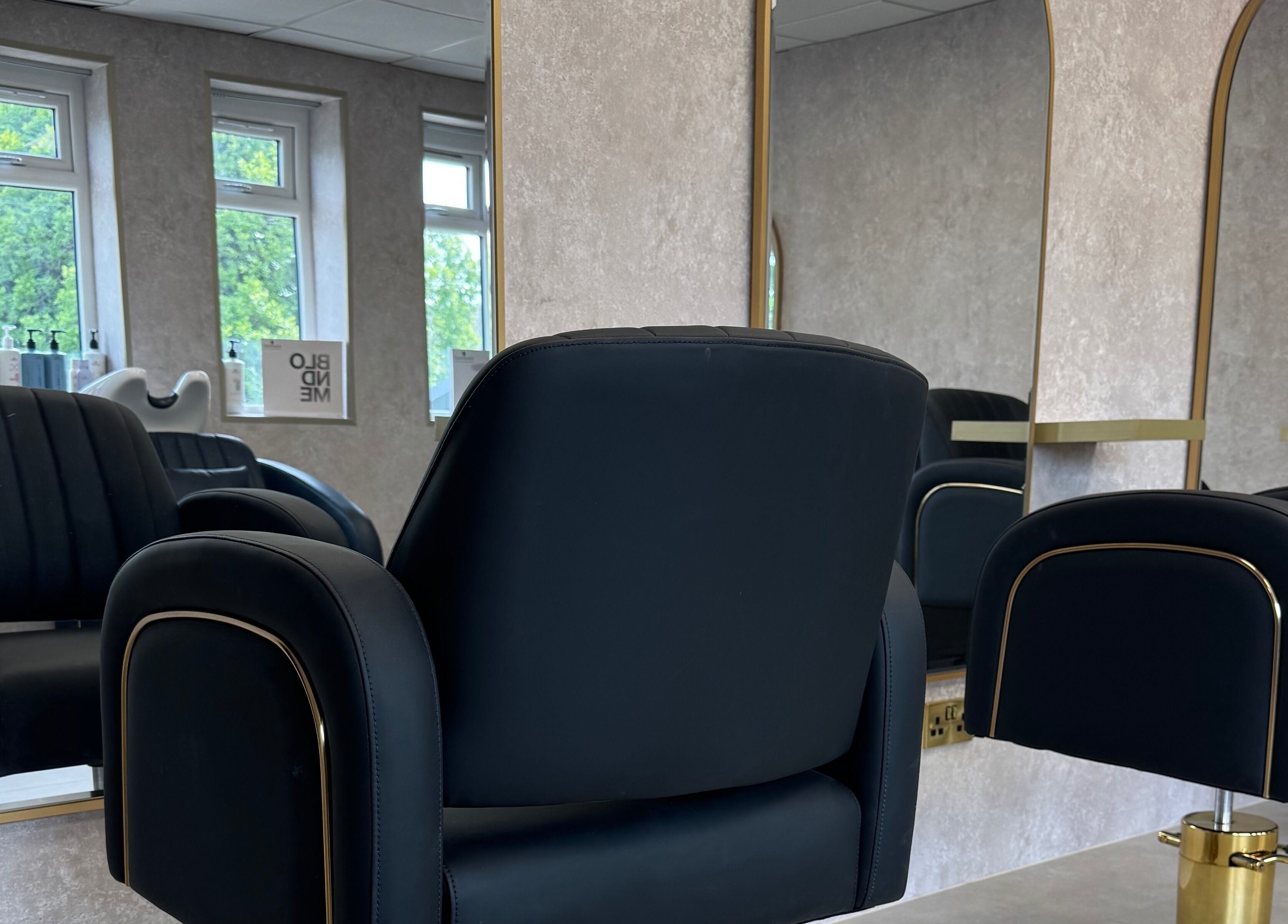 The Hair Edit by caitlin- at Solea Salon's sleek styling area with black chairs and mirrors in Motherwell, Scotland, GB.