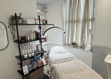 Relaxing treatment room at Skin Orchid, London, England, GB with a cozy bed and beauty products.